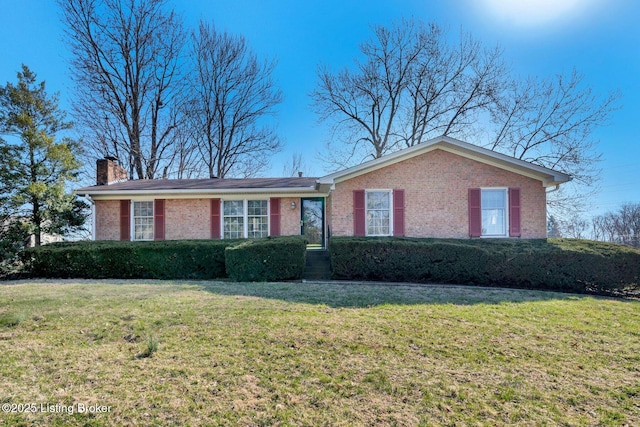 ranch-style house with brick siding, a chimney, and a front yard