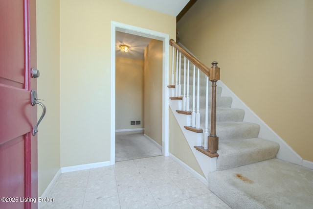 stairs with tile patterned floors, baseboards, and visible vents