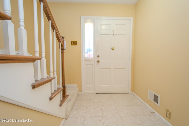 entryway featuring tile patterned flooring, visible vents, stairway, and baseboards