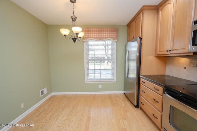 kitchen with visible vents, appliances with stainless steel finishes, light wood finished floors, decorative backsplash, and baseboards