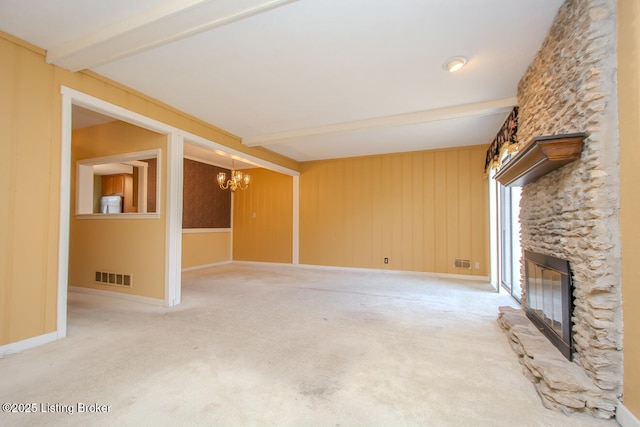 unfurnished living room featuring visible vents, beamed ceiling, a notable chandelier, a fireplace, and carpet flooring