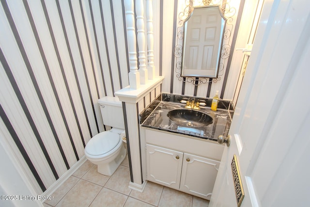 half bath featuring tile patterned floors, toilet, wallpapered walls, and vanity