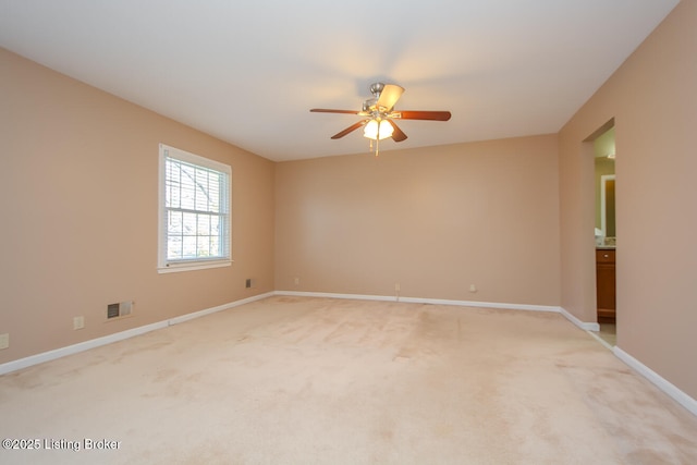 empty room with visible vents, baseboards, light colored carpet, and a ceiling fan