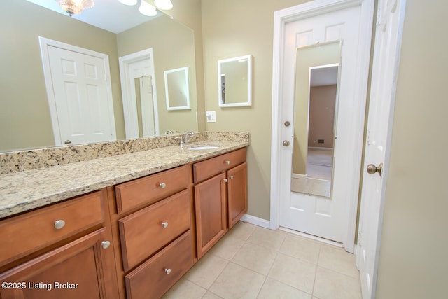 bathroom with tile patterned floors, baseboards, and vanity