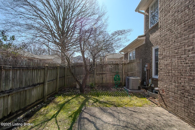 view of yard with central AC and a fenced backyard