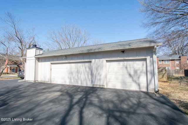 detached garage featuring fence