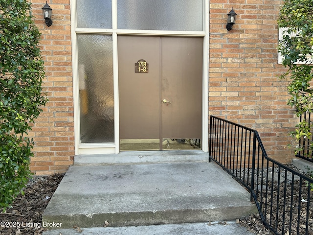 view of exterior entry featuring brick siding