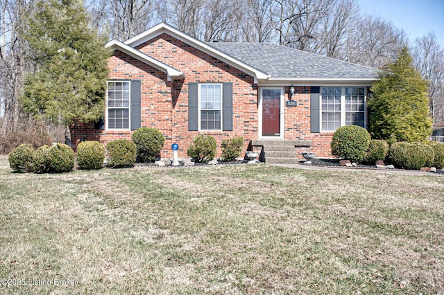 ranch-style house with brick siding, a shingled roof, and a front lawn