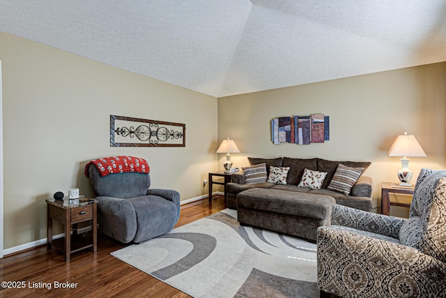 living room with a textured ceiling, baseboards, and wood finished floors