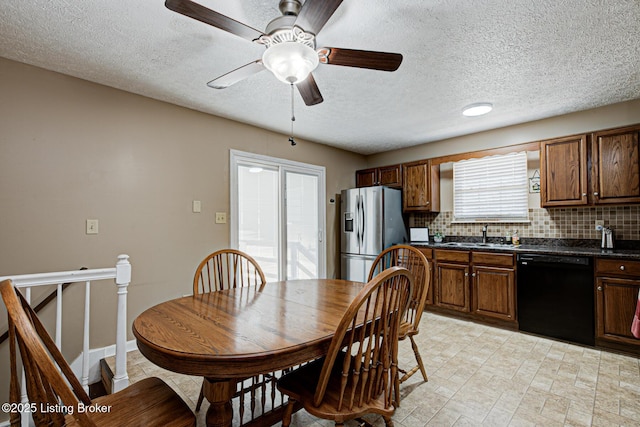 dining space featuring baseboards, a textured ceiling, and a ceiling fan