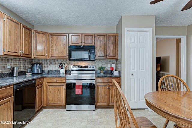 kitchen with dark countertops, black appliances, and brown cabinetry