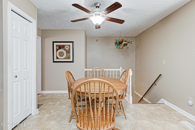 dining space featuring a textured ceiling and baseboards