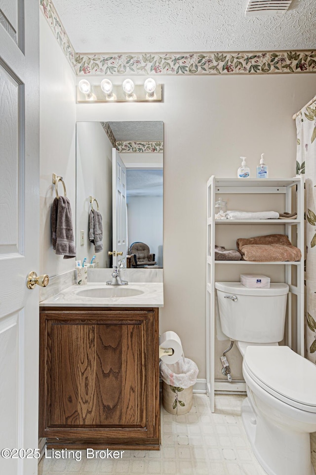 bathroom featuring vanity, a shower with curtain, a textured ceiling, tile patterned floors, and toilet