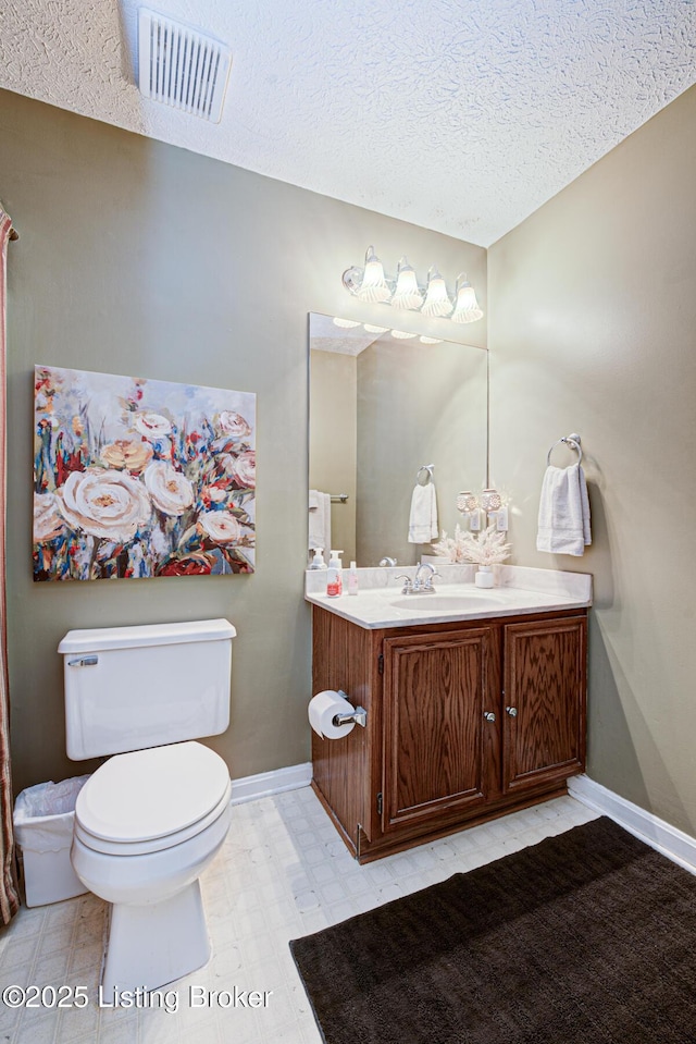 bathroom featuring visible vents, baseboards, toilet, tile patterned floors, and vanity