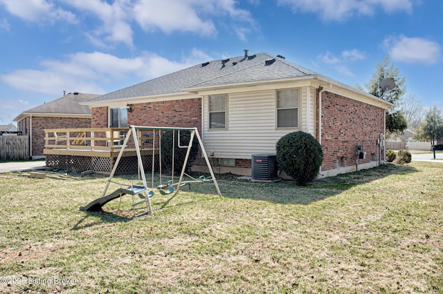 back of house featuring cooling unit, a lawn, and a wooden deck