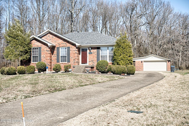 single story home with brick siding, a shingled roof, a detached garage, and an outdoor structure