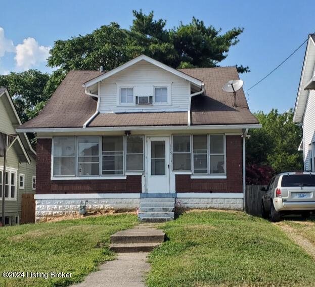 bungalow-style home featuring entry steps and a front lawn