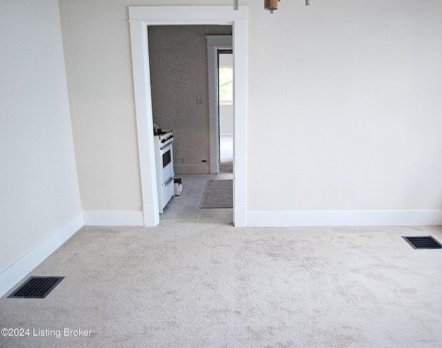 carpeted empty room featuring visible vents and baseboards