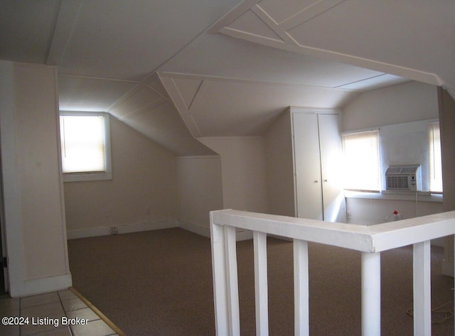 additional living space with tile patterned flooring, vaulted ceiling, cooling unit, and baseboards