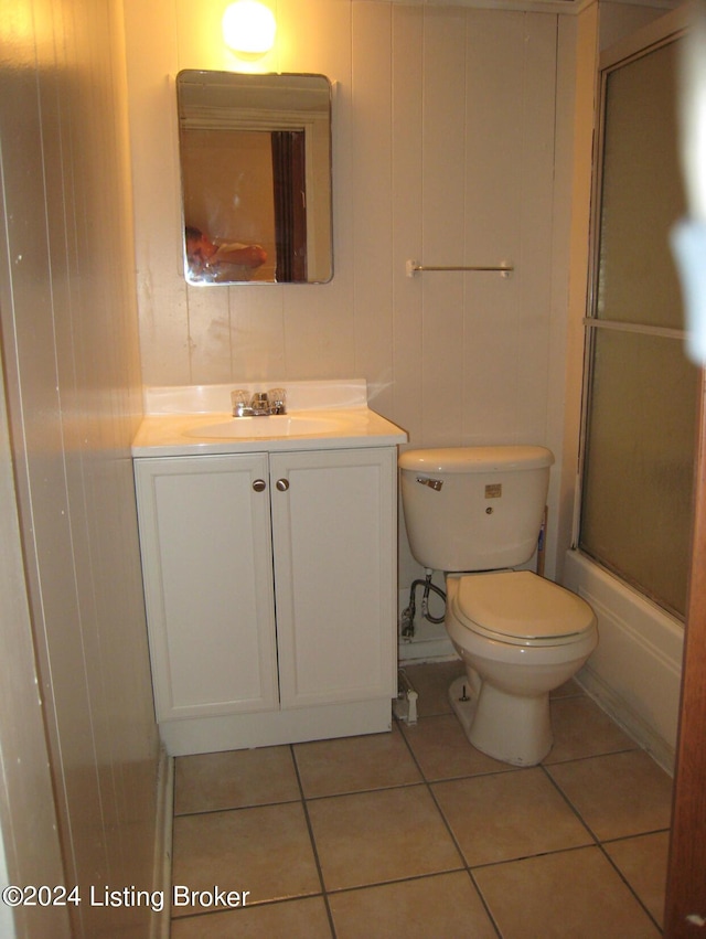 full bath with tile patterned flooring, an enclosed shower, toilet, and vanity