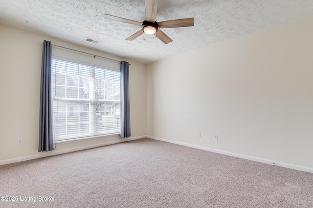 carpeted empty room featuring visible vents, baseboards, a textured ceiling, and a ceiling fan