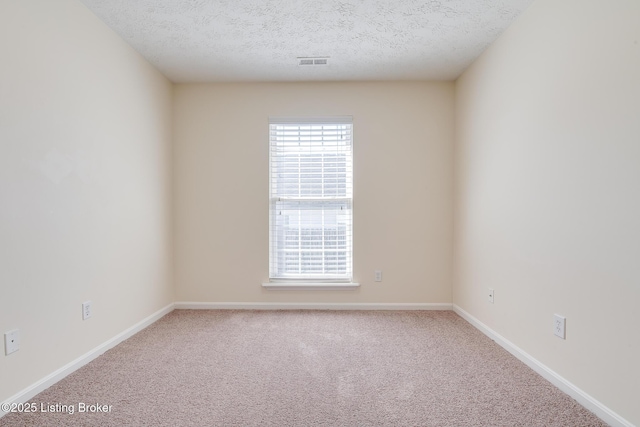 unfurnished room with baseboards, visible vents, carpet floors, and a textured ceiling