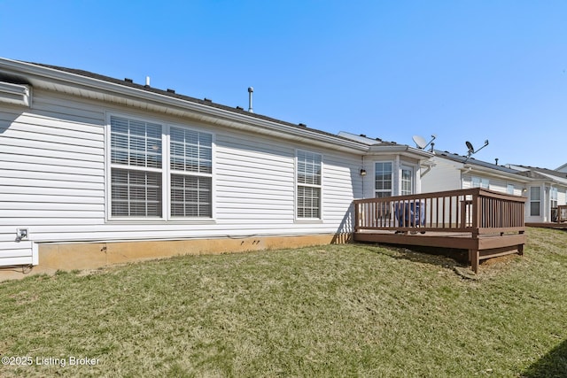 rear view of property with a lawn and a deck