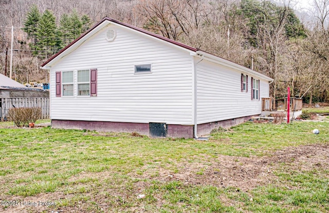 view of property exterior featuring a lawn and fence