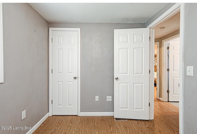 unfurnished bedroom with wood finished floors and baseboards