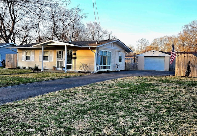 ranch-style house with a front yard, an outbuilding, driveway, and fence