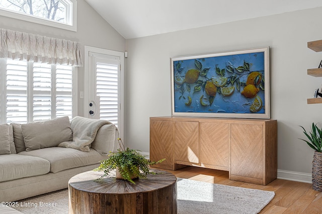 living room with baseboards, wood finished floors, and vaulted ceiling