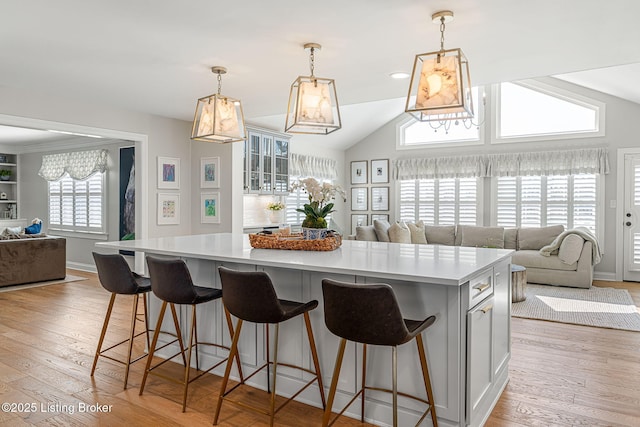 kitchen featuring a breakfast bar, light wood-style flooring, light countertops, a large island, and open floor plan