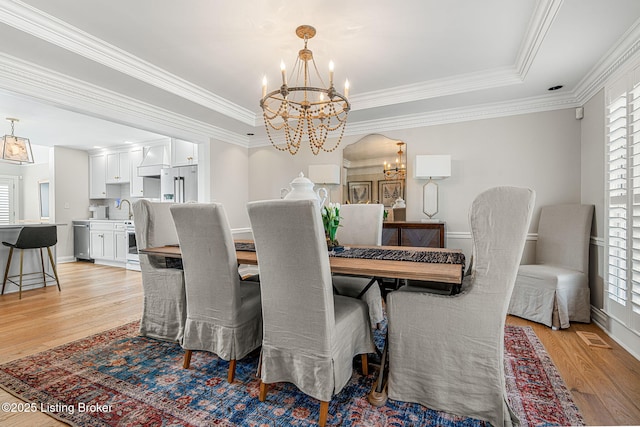 dining space with plenty of natural light, light wood-style floors, and an inviting chandelier