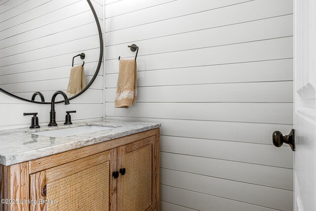 bathroom with wood walls and vanity