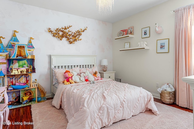 bedroom featuring visible vents, baseboards, and wood finished floors