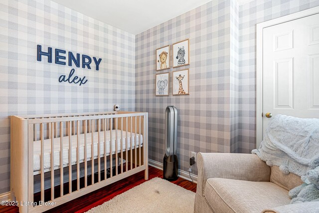 bedroom featuring wallpapered walls and wood finished floors