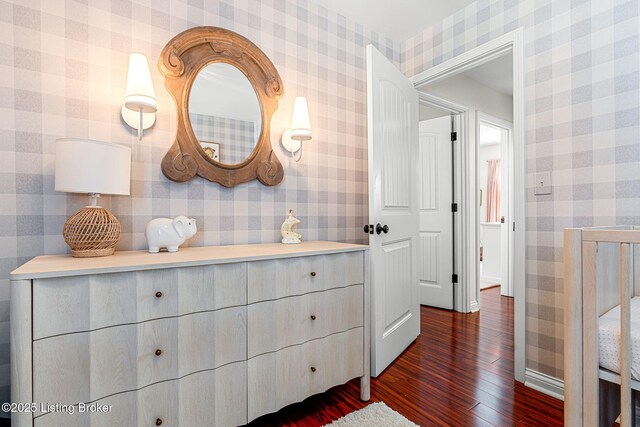 corridor with dark wood-type flooring and wallpapered walls