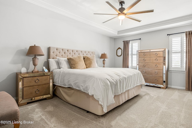 bedroom featuring baseboards, light colored carpet, ornamental molding, a raised ceiling, and a ceiling fan