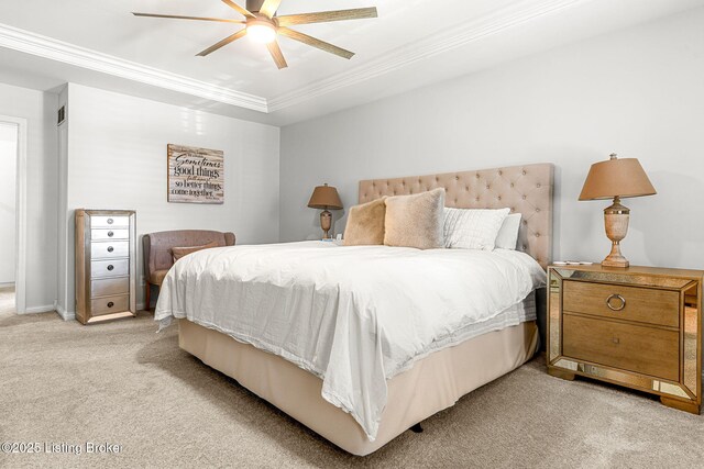 bedroom with ceiling fan, a tray ceiling, light colored carpet, and ornamental molding