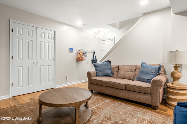 living room with stairs, wood finished floors, and baseboards