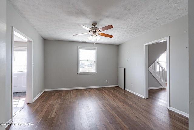 unfurnished room featuring dark wood-style floors, a textured ceiling, baseboards, and a ceiling fan