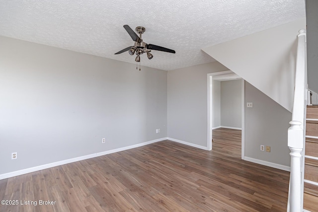 bonus room with baseboards, a textured ceiling, wood finished floors, and a ceiling fan