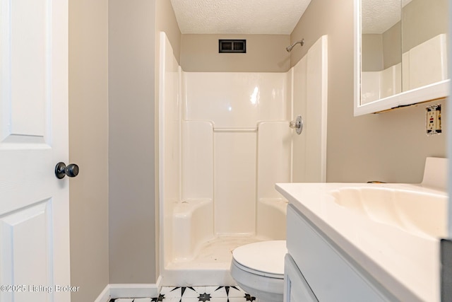 bathroom with visible vents, a textured ceiling, vanity, and walk in shower