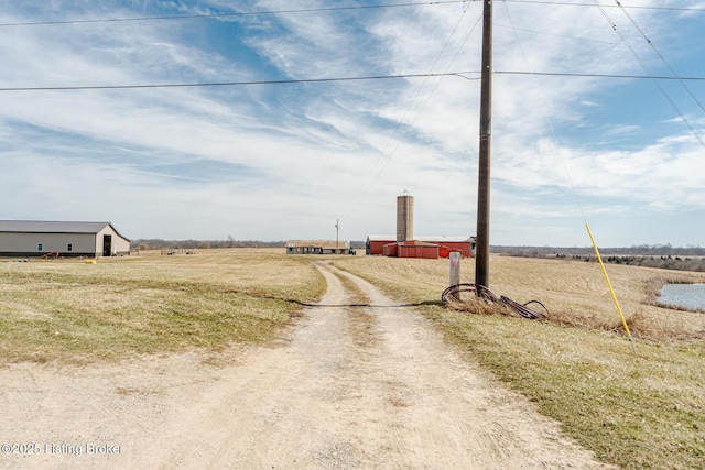 view of road featuring an outbuilding, a rural view, and dirt driveway