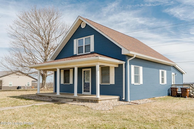 bungalow-style home with a porch, a front yard, and roof with shingles