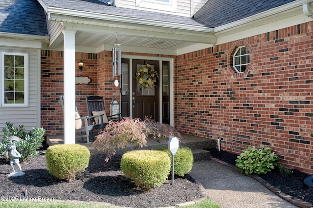 property entrance with brick siding and roof with shingles