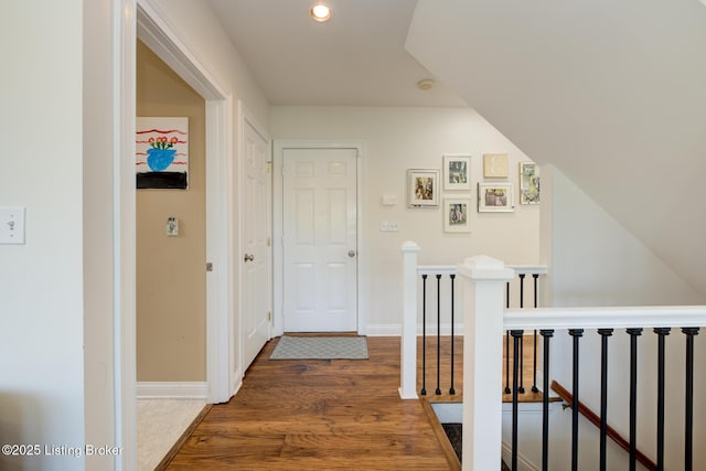 hallway featuring an upstairs landing, recessed lighting, baseboards, and wood finished floors