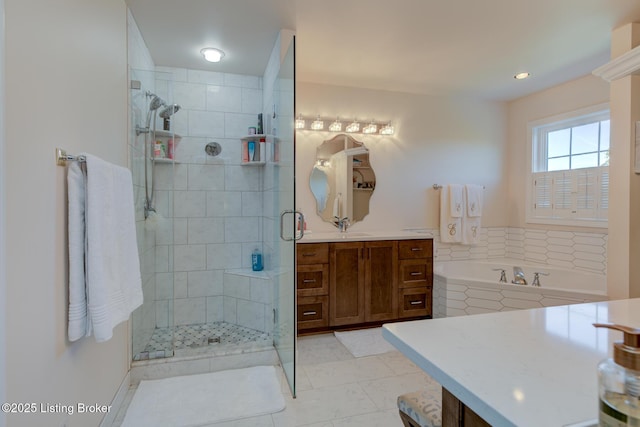 full bathroom with vanity, a bath, and a shower stall