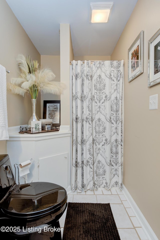 full bathroom featuring tile patterned floors, a shower with shower curtain, and baseboards