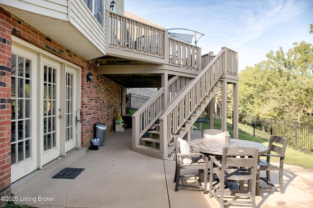 view of patio / terrace with stairway, a wooden deck, outdoor dining area, and fence